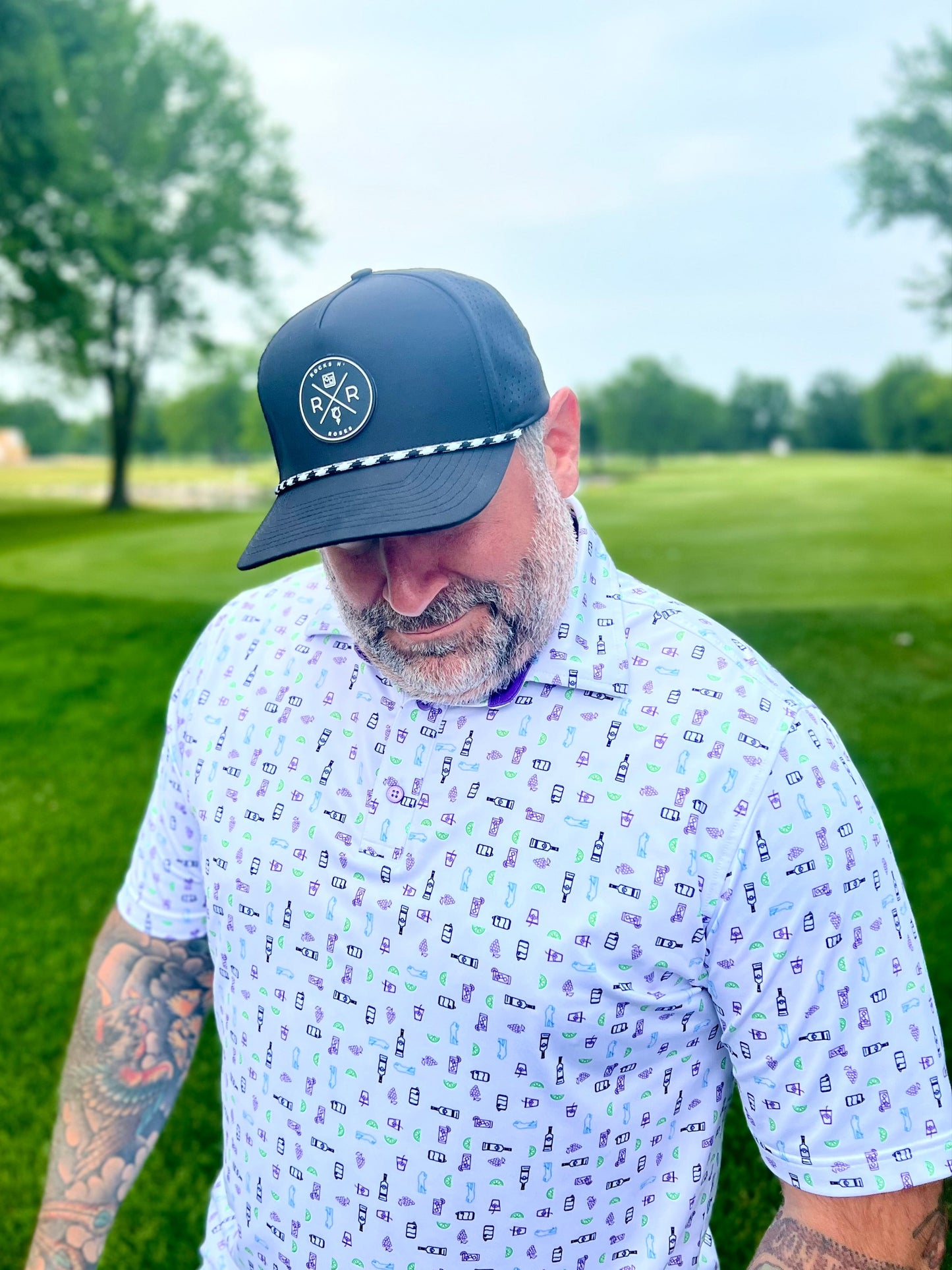 Man wearing the black Rocks N' Roses golf hat featuring a rubber logo and rope in black and white.
