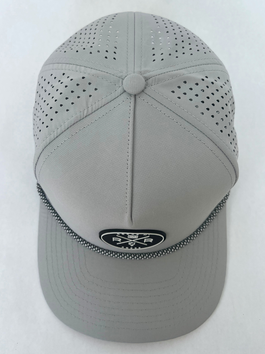 Overhead photo of the Rocks N' Roses Gray Golf Hat. This performance golf hat is a 5-panel water-resistant snapback featuring a laser perforated back, rubber logo and decorative rope.
