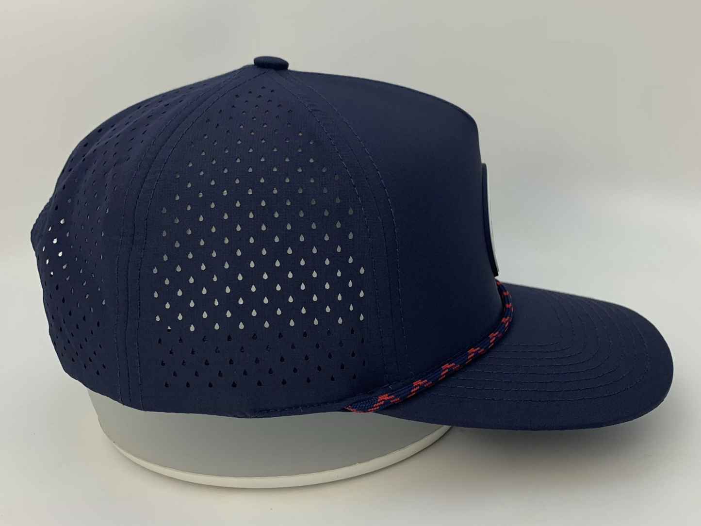 Rocks N' Roses Polyester Navy Blue Golf Hat showing laser perforated panels that deliver maximum breathability and red, and navy blue decorative rope.