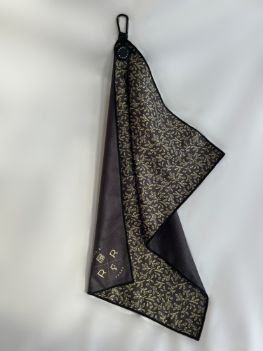 An image of the Rocks N' Roses Magnetic Golf Towel. On one side this magnetic golf towel has a black background with a golf floral pattern. The opposite side is plain black with a gold Rocks N' Roses logo in the bottom corner.
