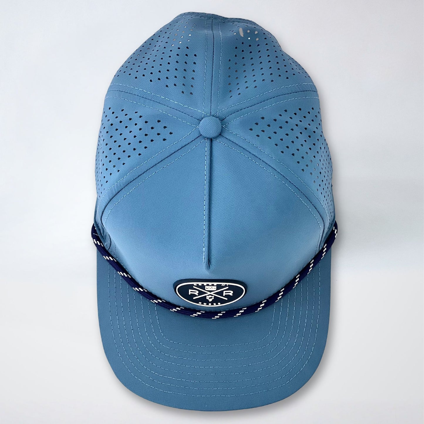 Rocks N' Roses Polyester Blue Steel Golf Hat overhead photograph showing laser perforated back panels navy blue and white rubber logo and navy blue and white decorative rope.