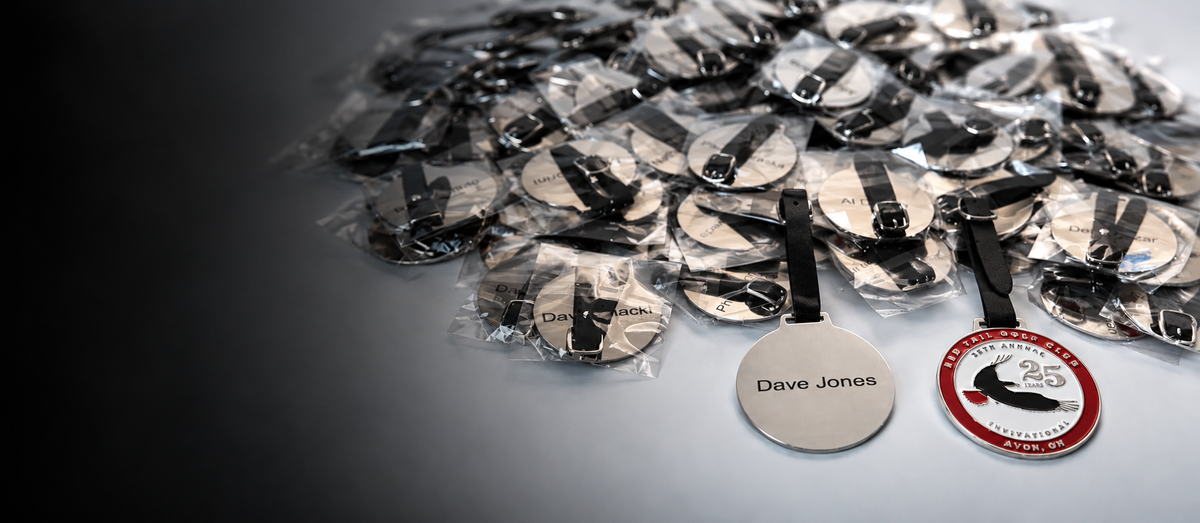 Image of a pile of laser engraved enamel golf bag tags for a 25th anniversary member-guest golf tournament invitational