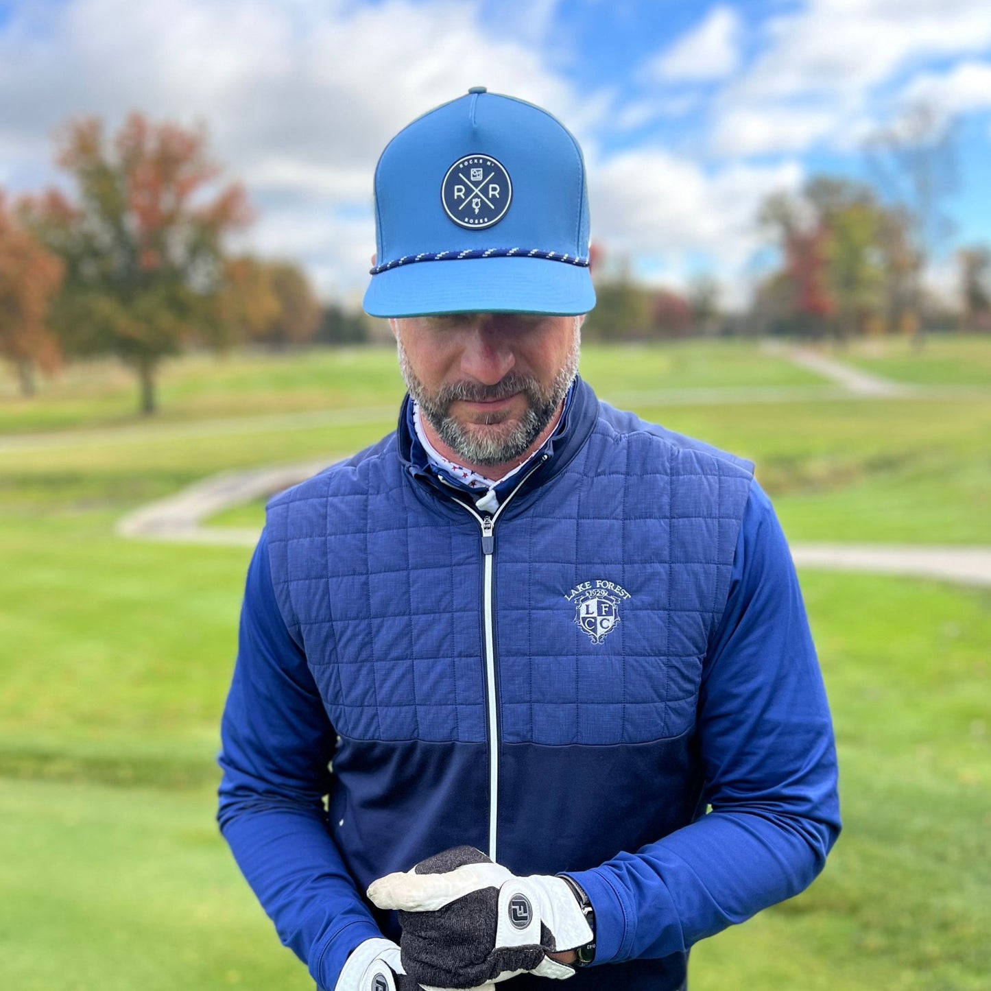 Man wearing the Rocks N' Roses Blue Steel Laser Perforated Golf Hat featuring a blue and white rope, 3D rubber logo, and adjustable snapback.