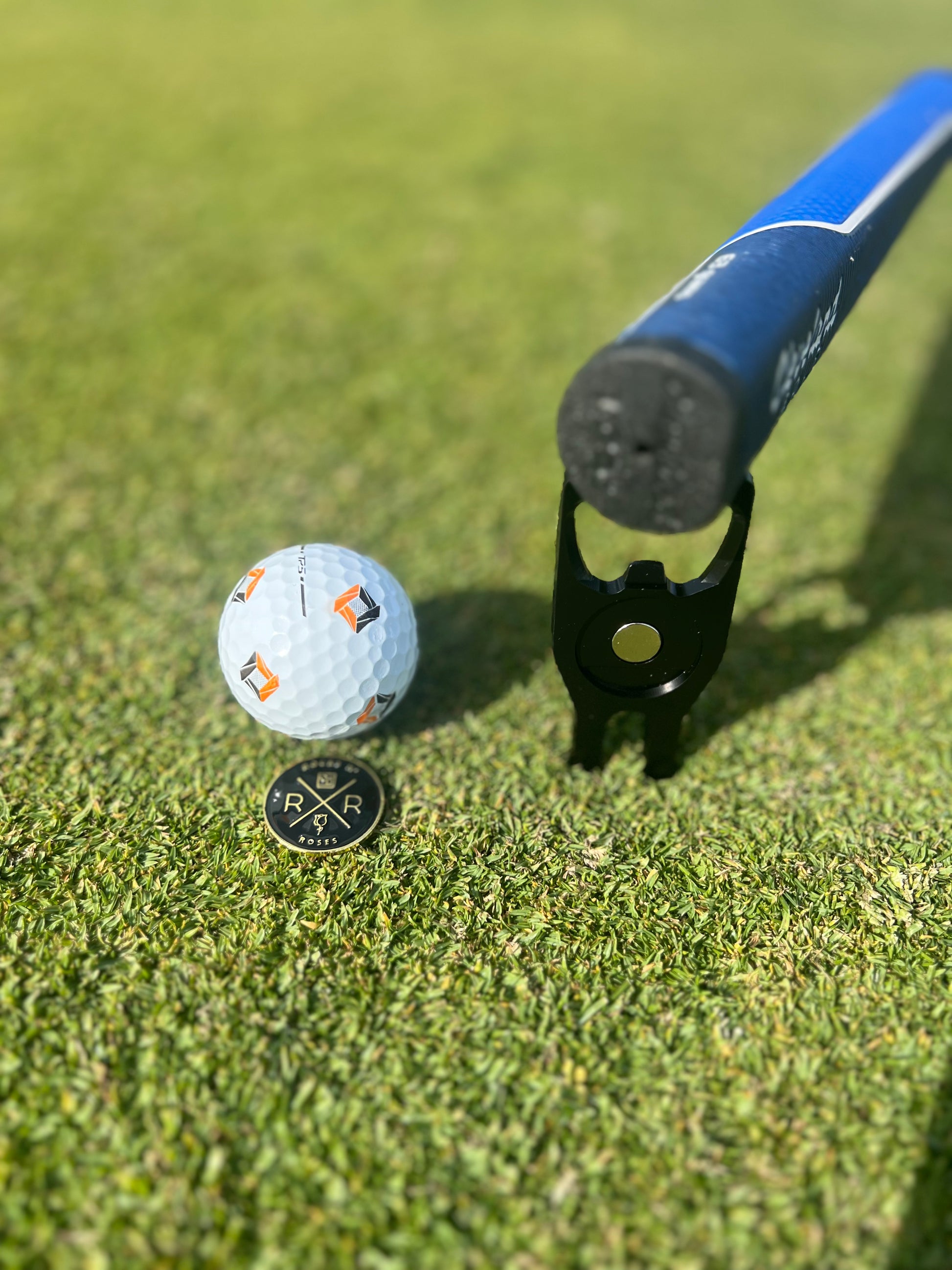 Image of the Rocks N' Roses Golf Multi-Tool featuring a divot repair tool, ball magnetic ball marker, bottle opener and club rest to keep your golf club's grip dry on a dewy morning.