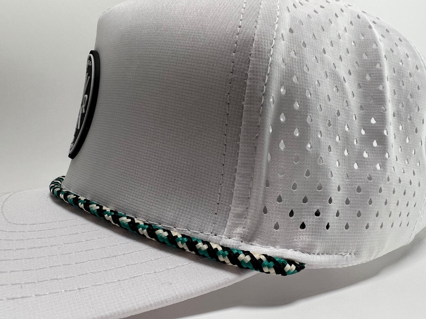 A close up shot of the side of the Rocks N' Roses White Golf Hat. This closeup shows the waterproof 100% polyester material used, later cut venting on the back four panels of the hat as well as the black, white, and teal checkered rope.