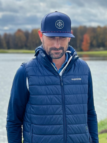 Man wearing the Rocks N' Roses Navy Blue Golf Hat featuring a Navy  blue and red rope, rubber logo, and laser perforated back 4 panels.