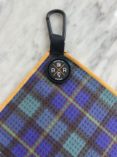 Close up shot of the Rocks N' Roses magnetic golf towel in a tartan plaid pattern. Close up shows the magnet and carabiner for attaching to your golf bag.