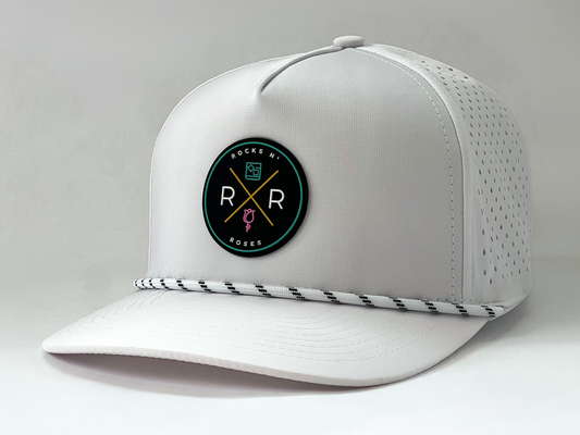 side shot of the Rocks N' Roses Tropical Sunset Golf Hat in White. This performance golf hat features a multi-color rubber logo and white rope with black accents.