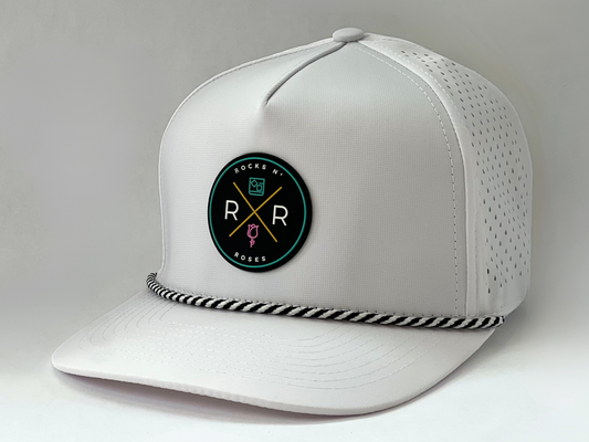 Side shot of the Rocks N' Roses Tropical Sunset Golf Hat. White golf hat with rubber logo on front and black and white rope.