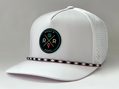 The new Rocks N' Roses Tropical Sunset Women's Golf Hat in White featuring a teal, pink, gold, white and black logo as well as a pink and black diamond rope.