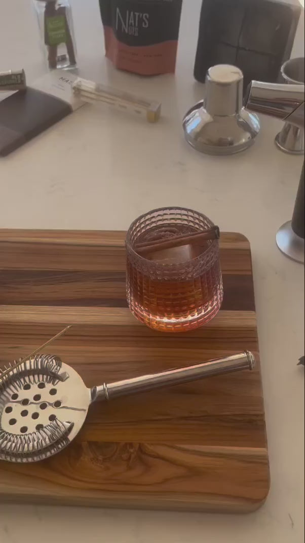 How to video showing how to make a Pecan Infused Old Fashioned cocktail using Nat's Nuts Cinnamon Whiskey Pecans, the, Rocks N' Roses Spinning Whiskey Bourbon Glass and Yes Cocktail Company's Old Fashioned infused sugar cubes.